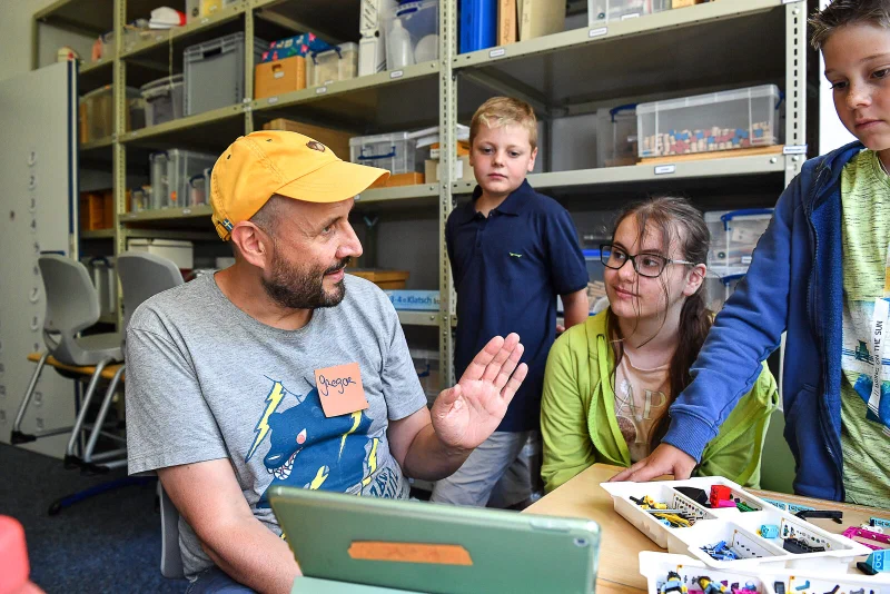 Kinder programmieren ihren Roboter am Laptop
