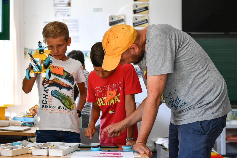 Kinder bauen einen Lego-Spike-Roboter im Ferienkurs